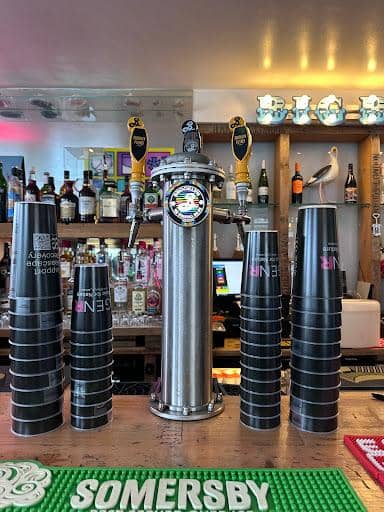 Bar staff serving draft beer in branded reusable pint cups