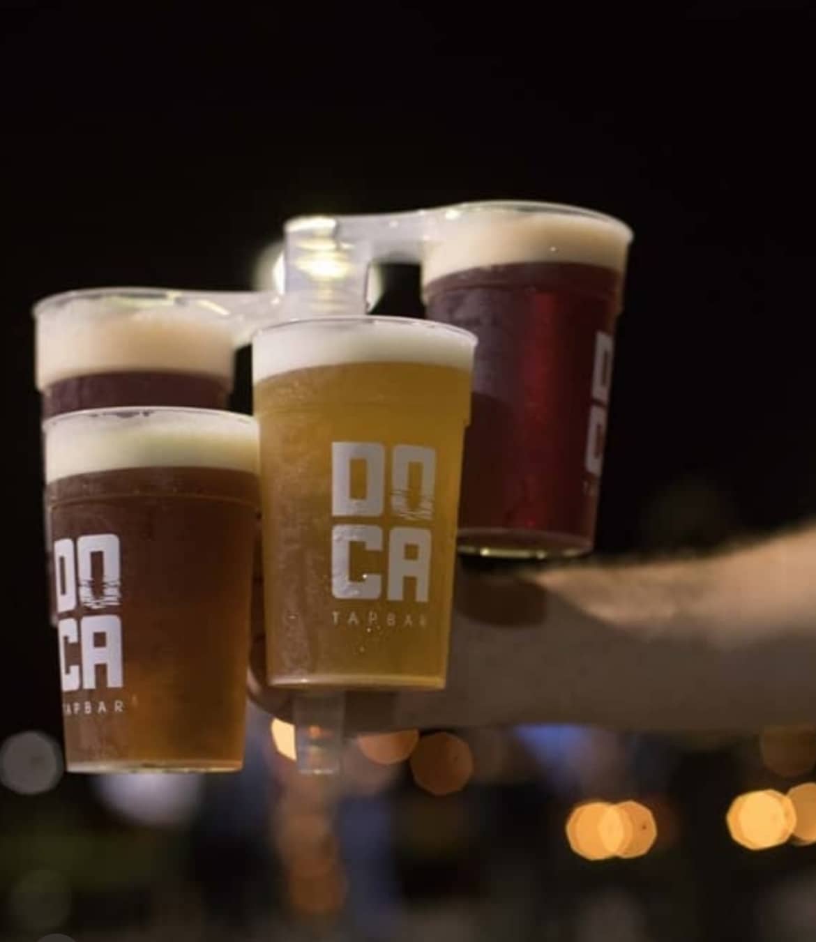 Bar staff serving draft beer in branded reusable pint cups